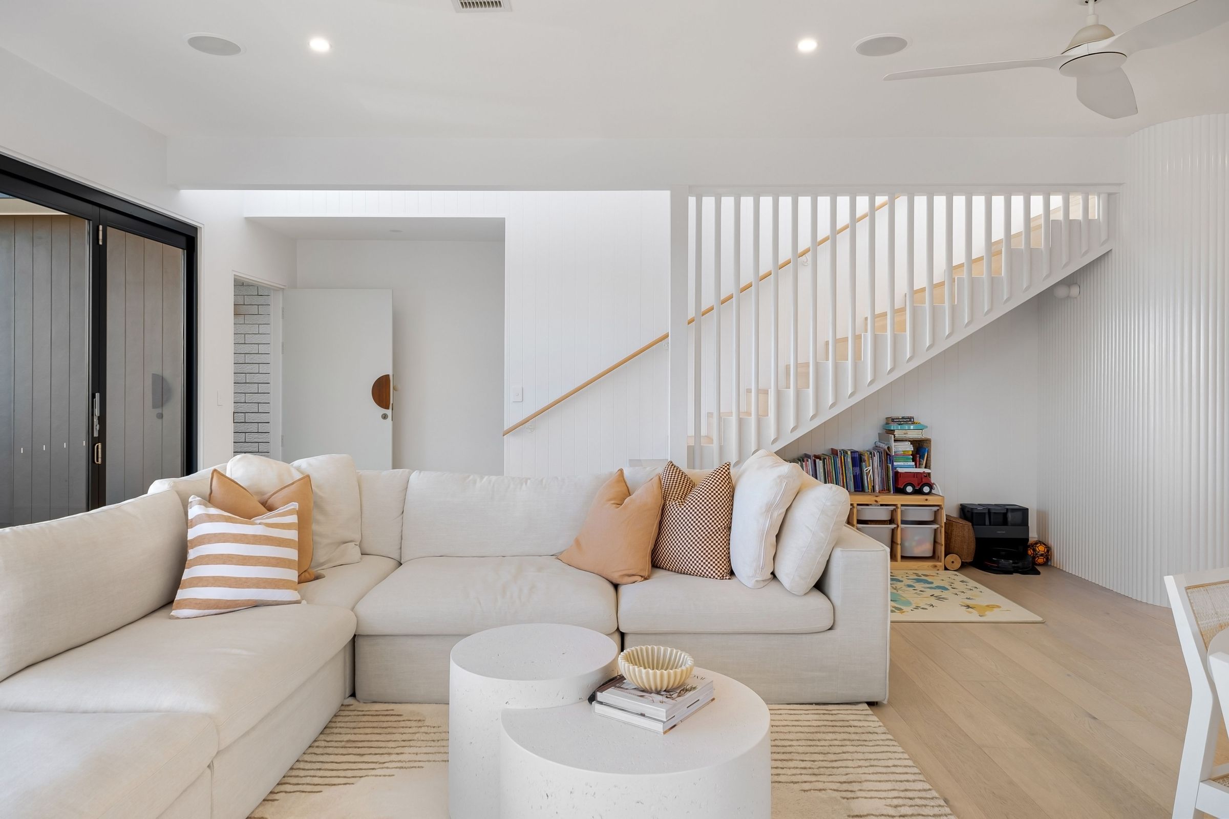 Bright, tidy living room with a white sectional sofa and light wood floors